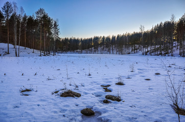 Winter landscape. Frozen lake. Snowdrifts. Sunset