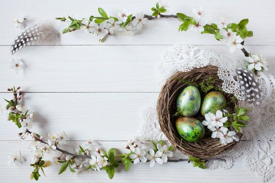 Easter background with a nest, eggs and branch with flowers