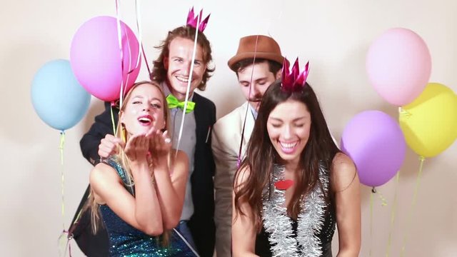 Four funny crazy friends having great time in party photo booth
