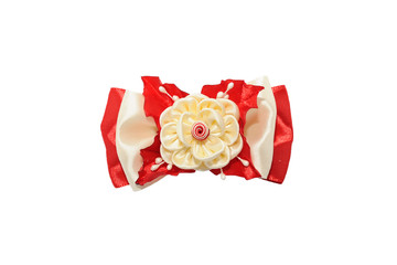 Kanzashi. Beige artificial flower on a red bow isolated on white
