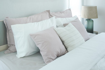 Fototapeta na wymiar Pink pillows on bed in modern bedroom interior