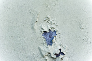 Rotten concrete wall with blown paint