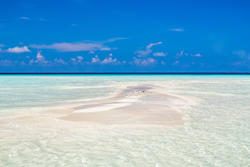 Small white sand island in ocean on Maldives