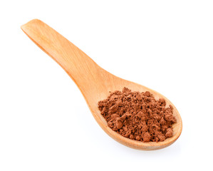 Cocoa powder in a wood spoon on white background