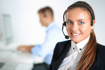 Happy female wearing headset and sitting on the desk