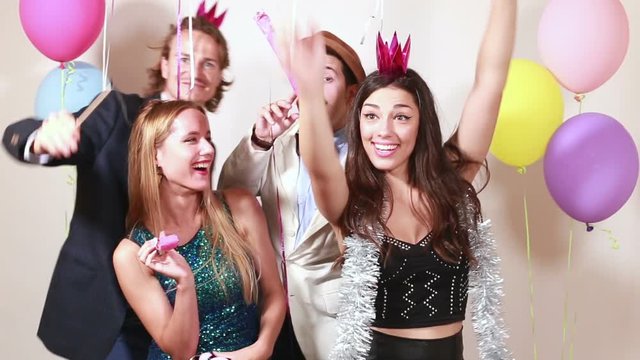 Group of funny crazy friends having great time in party photo booth