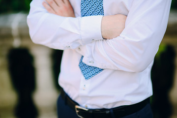 Male hands crossed on chest. Hands of the groom on the chest.