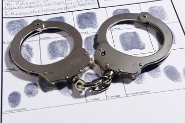 Handcuffs laying on top of fingerprint chart