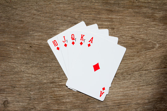 Five card of red diamond royal straight flush on wooden background