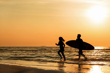 A surfer with his surfboard running to the waves
