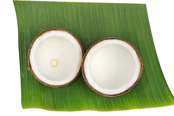 Coconut with shell on banana leaf isolated on white background