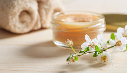 Obraz na płótnie Canvas Moisturizing cream and almond blooms on wooden background