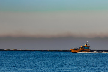 Orange pilot ship sailing from the Baltic sea in Latvia