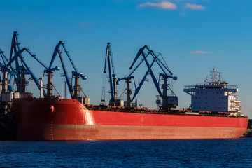 Red cargo ship loading in the port of Riga, Europe