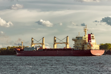 Fototapeta premium Red cargo ship sailing to the port of Riga