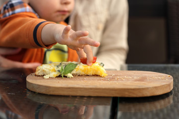Toddler takes slice of tomato