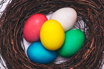 Easter eggs in nest on marble background.