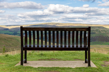 Fototapeta na wymiar Bench with view over the Yorkshire Dales, near Thwaite, North Yorkshire, UK