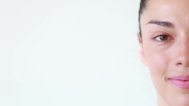 Close up of half face portrait of beautiful young woman without makeup isolated on white background