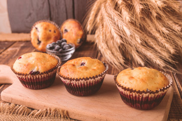 Muffins on wooden background on rustic style. Cupcake with currant
