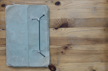 Old, washy blue folder on wooden desk