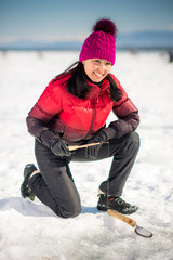 Fototapeta na wymiar Woman ice-fishing in the winter