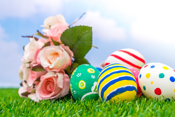 Easter eggs with artificial flower on Fresh Green Grass