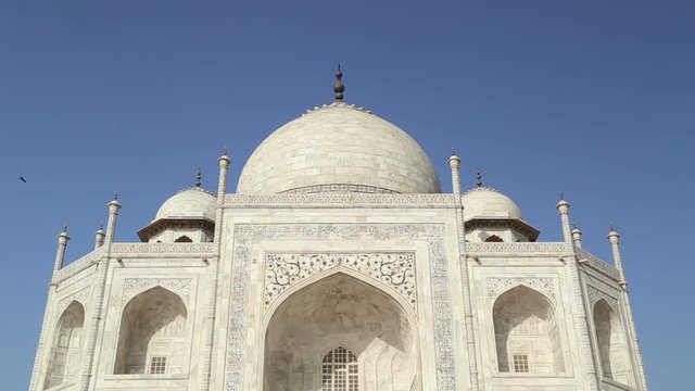 AGRA, INDIA - 26 FEBRUARY 2015: Outdoor wall of Taj Mahal, with people passing in front.