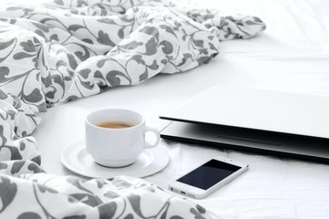 The bedroom on the bed, morning coffee, phone and laptop