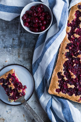 cherry fruit pie on a black tray on white speckled background