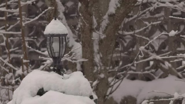 Heavy snow fall with a garden light in background