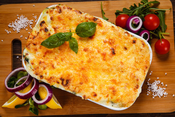 Lasagna served on cutting board