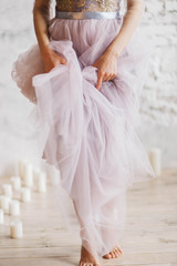Fototapeta na wymiar the bride girl in a gorgeous dress of tulle silk goes straight feet close-up lifting dress