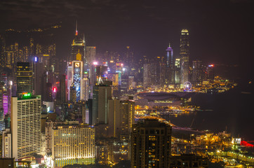 Naklejka premium Skyscrapers and other buildings on Hong Kong Island in Hong Kong, China, viewed from the Braemar Hill on a foggy and cloudy night.