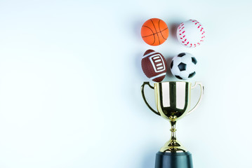 Golden trophy, Football toy, Baseball toy, Basketball toy and Rugby toy isolated on white background with copy space.Concept winner of the sport.