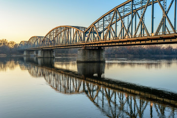 Fototapeta na wymiar Jozef Pilsudski road bridge reflected in Vistula river in the morning. Torun, Poland. Europe.