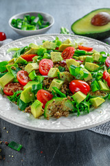 Quinoa tabbouleh salad with avocado, tomatoes, cucumber, green onion. Concept healthy food.