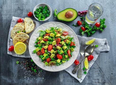 Quinoa tabbouleh salad with avocado, tomatoes, cucumber, green onion. Concept healthy food.