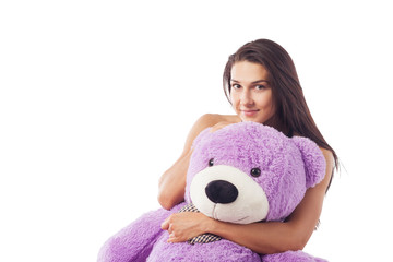 Woman with a huge teddy bear on the bed