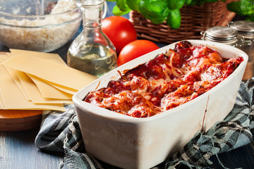 Hot tasty lasagna with spinach in ceramic casserole dish