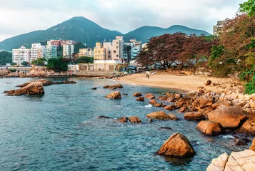 Tuinposter Rotsachtige kust en klein zandstrand van Stanley Bay in Hong Kong. Prachtig schilderachtig landschap met water, bergen, rotsen en gebouwen © Wilding