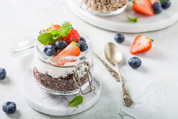 Gluten free breakfast with red quinoa, yogurt and berries in glass jar. Healthy super foods concept with copy space.