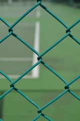 Security wire mesh fence with blurred tennis court background