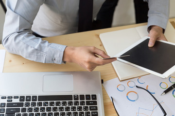 Businessman hand holding a Credit card intent to made a online payment with digital tablet on his desk.