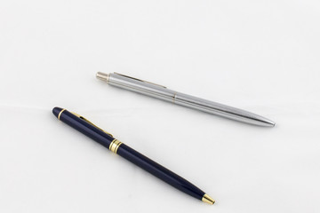 Gold-blue and silver pen on a white background, business concept