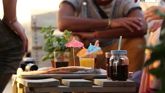 View of table with full of colorful cocktails and pizza