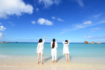 Fototapeta na wymiar 海辺で遊ぶ三人の女性 