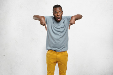 Check this out! Cropped studio shot of attractive excited young African male in t-shirt and mustard...