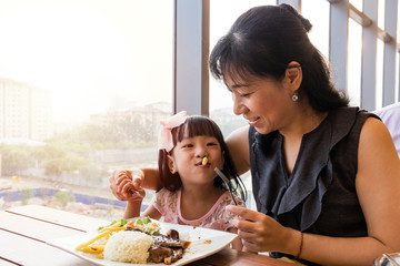 Asian Chinese mother and daughter eating steak