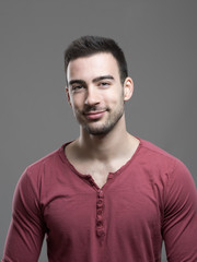 Obraz premium Happy young stylish stubble man smiling at camera over gray background